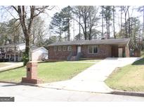 Charming brick home featuring a well-maintained lawn and convenient covered parking area at 3647 Glen Mora Dr, Decatur, GA 30032