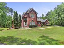 Charming two-story brick home with manicured lawn and mature trees at 643 Old Greenville Rd, Fayetteville, GA 30215