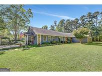 Charming single-story home with stone accents, well-maintained lawn, and inviting curb appeal on a sunny day at 880 Brooks Woolsey Rd, Brooks, GA 30205