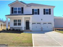 Inviting two-story home with a two-car garage, covered porch, and well-manicured lawn at 126 Oakchase Park Lane, Hampton, GA 30228