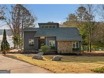 Contemporary home featuring stone accents and a well-manicured front yard with lake views at 1190 Plantation Dr, Villa Rica, GA 30180