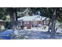 Cozy brick home featuring a covered front porch and a well-maintained yard with mature trees at 6842 E Sherwood Dr, Riverdale, GA 30274