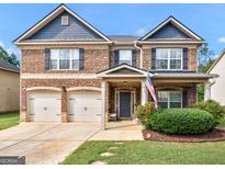 Inviting brick home features a two-car garage, manicured lawn, and a welcoming front porch at 346 M J Mccarthy Way, Hampton, GA 30228