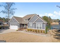 Charming gray home with a well-manicured lawn, attached garage, and beautiful landscaping at 1278 Heritage Dr, Villa Rica, GA 30180