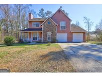 Charming two-story home featuring stone accents, a cozy porch, and an attached two-car garage at 110 Paces Dr, Fayetteville, GA 30215