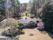 Spacious ranch-style home boasts mature landscaping, flowering trees, and cozy front porch at 2218 Young Rd, Stone Mountain, GA 30088