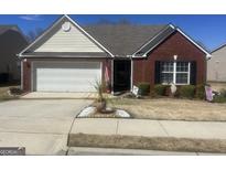 Charming one-story brick home features a well-manicured lawn, white garage door and black shutters at 507 Mockingbird Ln, Loganville, GA 30052