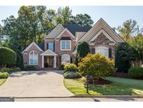 Beautiful two-story brick home featuring a well-manicured lawn and inviting curb appeal at 7085 Wakehurst Pl, Cumming, GA 30040