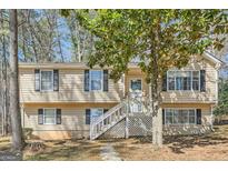 Inviting two-story home featuring a charming front porch and manicured landscaping at 4605 Woodcroft Cv, Snellville, GA 30039