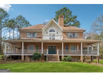 Charming brick home featuring a spacious wrap-around porch and well-maintained lawn at 2200 Gleneagle Nw Ct, Conyers, GA 30012