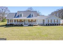 Charming single-Gathering home with a covered front porch and well-manicured lawn on a sunny day at 8 Cameron St, Moreland, GA 30259
