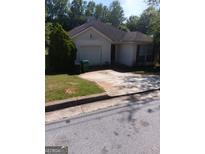 Charming single-story home with attached garage and well-maintained front yard at 6588 Browns Mill Ferry Dr, Lithonia, GA 30038