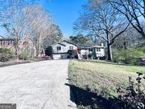 Charming home with a red door, nestled in a lush, green lawn and surrounded by mature trees at 4436 Old Country Way, Snellville, GA 30039