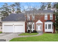 Charming two-story brick home with a well-manicured lawn, a two-car garage and a welcoming front entrance at 5105 Cascade Hills Cir, Atlanta, GA 30331