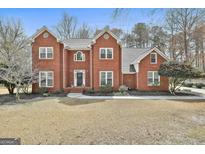 Charming two-story brick home with a well-manicured front yard and classic architectural details at 208 Pinnacle Ct, Peachtree City, GA 30269