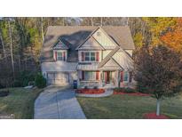 Charming home featuring a two-car garage, red shutters, and landscaped front yard at 5997 Wildcreek Rd, Sugar Hill, GA 30518