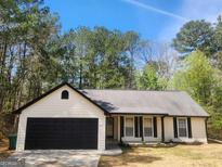 Charming single story home with black trim, siding, and a well manicured front yard at 1335 Sweetwater Blf, Snellville, GA 30039