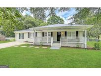 Charming home featuring a well-manicured lawn, inviting front porch, and fresh exterior paint at 245 Carole Dr, Oxford, GA 30054