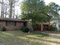 Charming brick home featuring an expansive front yard and attached garage at 3045 Weslock Cir, Decatur, GA 30034