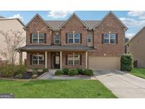 Charming brick two-story home features a welcoming front porch, manicured landscaping and attached two car garage at 34Oo Palmer Lake Pointe, Douglasville, GA 30135
