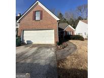 Two-story brick home featuring a wide driveway, two-car garage, and a well-manicured lawn at 4401 Chestnut Lake Ave, Stonecrest, GA 30038