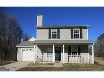 Charming two-story home features a welcoming front porch and attached garage at 9590 Sleepy Hollow Ln, Jonesboro, GA 30238