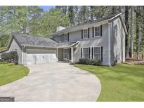 Charming two-story home with a well-manicured lawn, mature trees, and an inviting driveway leading to an attached garage at 202 Saltlick Trce, Peachtree City, GA 30269
