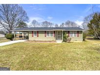 Charming single-story home with a well-maintained front yard and covered driveway at 1055 Adrian Sw Cir, Conyers, GA 30094