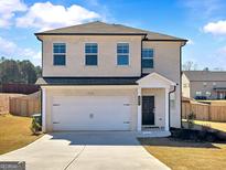 Two-story home featuring a brick exterior, attached two-car garage, and well-manicured front lawn at 301 Amsterdam Way, Hampton, GA 30228