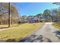 Traditional two-story brick home with blue shutters, a welcoming porch, and a beautifully manicured lawn at 671 Ellison Rd, Tyrone, GA 30290