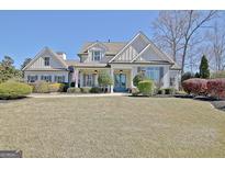 Charming two-story home featuring well-manicured lawn and inviting blue double-door entry at 341 Beaumont Farms Dr, Sharpsburg, GA 30277