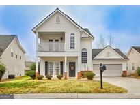 Charming two-story home featuring a welcoming front porch and attached two-car garage at 306 Turtle Pointe Dr, Carrollton, GA 30116