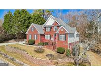 Beautiful two-story brick home featuring manicured landscaping and a charming front porch at 10119 Azalea Dr, Covington, GA 30014
