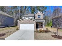 Charming brick two-story home features a manicured front yard and attached two car garage at 1659 Hay Patch Ln, Loganville, GA 30052