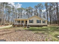 Charming single-story home with a welcoming front porch and a beautifully landscaped yard surrounded by mature trees at 179 Green Valley Rd, Fayetteville, GA 30214