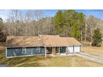 Charming home with a welcoming front porch, mature trees, and a two-car garage at 105. Meadow Springs Ct, Locust Grove, GA 30248