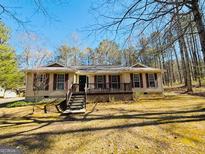 Charming ranch home with a inviting front porch, surrounded by mature trees and a well-maintained lawn at 127 Circle H Rd, Sharpsburg, GA 30277