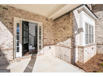 Elegant brick home entrance featuring a black front door with sidelights and staircase view upon entry at 1300 Winfair Ne Ln, Brookhaven, GA 30329