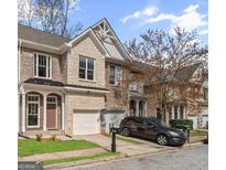 Charming townhome featuring a brick and stone facade, attached garage, and well-manicured landscaping at 4866 Pinnacle Dr, Stone Mountain, GA 30088