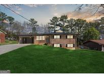 Charming split-level home featuring a brick facade, well-maintained lawn, and a convenient carport at 1142 Shoreham Dr, Atlanta, GA 30349