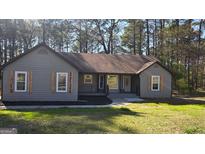 Charming single-story home with natural wood shutters, landscaping, and inviting entrance at 127 Brookwood Estates Trl, Stockbridge, GA 30281