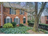 Charming brick townhome with manicured landscaping, dark shutters, and an inviting entrance at 213 The South Chace Ne, Sandy Springs, GA 30328
