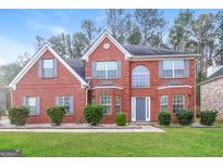 Charming two-story red brick home with a manicured front lawn and gray shutters adding curb appeal at 139 Surge Stone Ln, Stockbridge, GA 30281