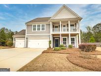 Charming two-story home featuring a double front porch and an attached three-car garage at 305 Roundwood Way, Peachtree City, GA 30269