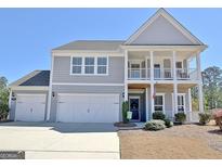 Charming two-story home with a welcoming front porch and attached two-car garage at 305 Roundwood Way, Peachtree City, GA 30269