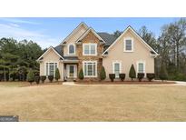 Beautiful exterior view of the home showcasing the well-manicured lawn, stone accents, and elegant facade at 6275 Montlake Ave, Mcdonough, GA 30253