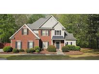 Charming two-story home featuring a brick facade, gray siding, and well-manicured landscaping at 255 Squire Ln, Fayetteville, GA 30214