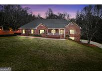 Charming brick home featuring a well-manicured lawn and inviting front porch and meticulously maintained landscaping at 503 Clearwater Dr, Mcdonough, GA 30252