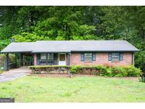 Charming brick ranch home with a well-maintained front yard and covered carport at 2102 Mulkey Sw Rd, Marietta, GA 30008