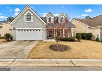 Charming traditional home features a two-car garage and a well-manicured front yard at 211 Collierstown Way, Peachtree City, GA 30269